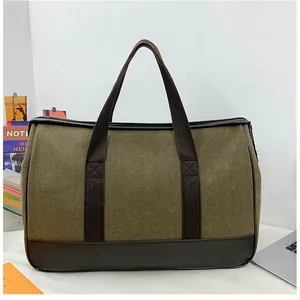 Close-up of olive canvas travel bag with dark brown leather base and laptop accessory