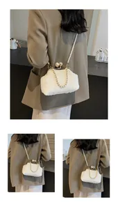 Détail du sac coquille en peluche blanc avec chaînes de perles et fermoir doré chic