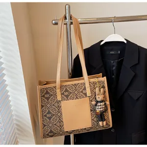 Detail of a beige tote bag with geometric print and a cute rabbit charm on a metal hanger