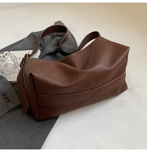 Vue de dessus du sac croissant marron foncé avec texture grainée et plis souples