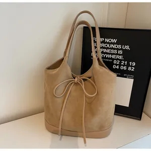 Detail of khaki frosted suede tote bag with elegant bow drawstring and smooth leather trim