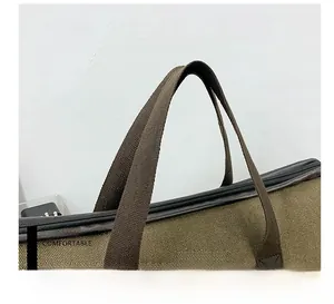 Detail of reinforced double-stitched brown canvas bag handles with fashion label