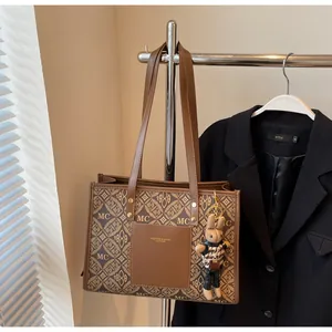 Detail of vintage monogram tote bag in coffee synthetic leather with cute rabbit charm
