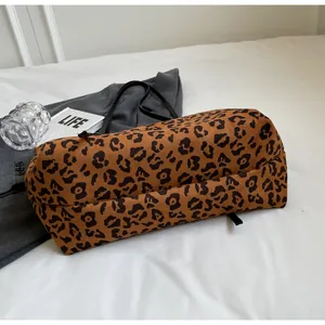 Detail of a leopard print tote bag with black straps on a lifestyle background