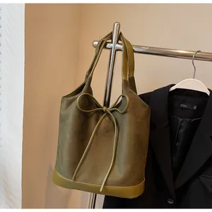 Detail of olive green tote bag with matte finish suede and elegant bow knot decoration