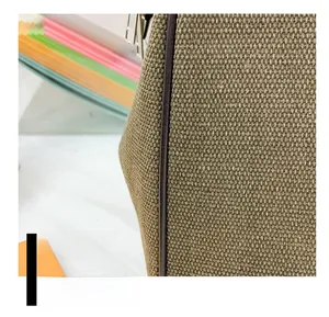 Close-up of durable khaki canvas fabric and premium brown leather trim on a travel bag