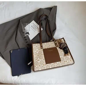 Detail of contrast tote bag with monogram print, leather pocket, and cute bear pendant