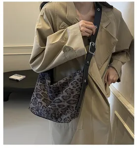 Sac hobo chic à imprimé léopard avec bandoulière réglable à œillets porté par mannequin