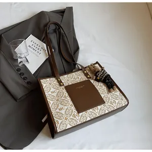 Close-up of vintage monogram tote bag with brown leather pocket and teddy bear charm