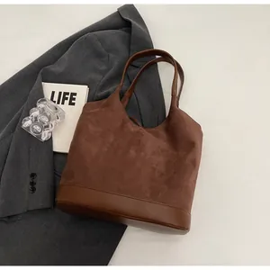 Close-up of brown suede tote bag with leather patchwork and spacious interior design