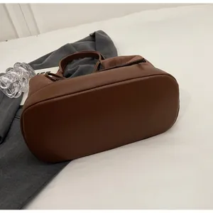 Detail showing the mixed texture of smooth leather and matte suede on dark brown tote