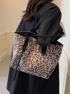 Large capacity leopard print tote bag with black straps worn by a model for daily use