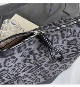 Détail du sac léopard avec fermeture éclair argentée et tirette en cuir noir tressé