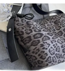 Gros plan du sac à bandoulière léopard gris foncé avec détails de sangle en cuir noué