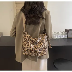 Détail d'un sac à bandoulière léopard tendance avec large sangle porté par un modèle