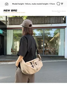 Detail of a khaki nylon crescent crossbody bag with double pockets and wide strap