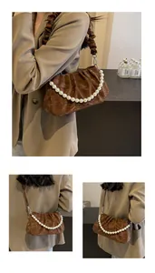 Detail of brown pleated shoulder bag featuring elegant pearl chain and ruched strap