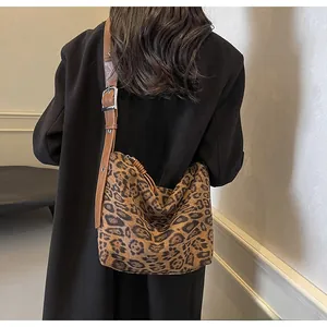 Détail de la bandoulière réglable en cuir marron et boucle sur le sac à imprimé léopard