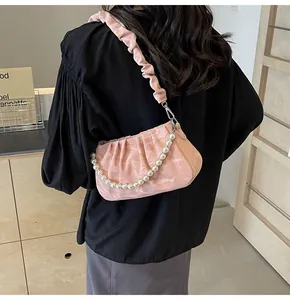 Pink pleated underarm bag with decorative pearl chain and subtle monogram patterns