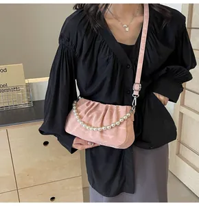 Detail of pink pleated cloud bag with pearl chain handle and silver hardware