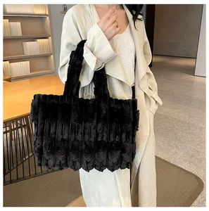 Detail of soft black faux fur tote bag with striped texture shown on shoulder