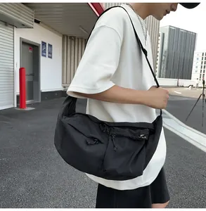 Detail of a black nylon crossbody bag featuring waterproof fabric and adjustable strap