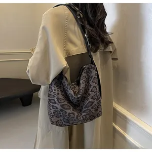Détail du sac bandoulière léopard avec sangle en cuir ajustable et texture en toile
