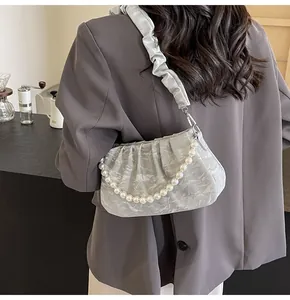 Detail shot of the ruched shoulder bag with pearl chain and scrunchie strap on grey blazer