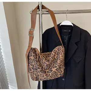 Détail du sac à bandoulière léopard avec bandoulière réglable en cuir marron et boucle