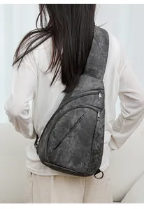 Détail du sac de poitrine gris vintage en cuir PU avec plusieurs poches zippées sur modèle