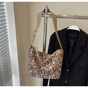Détail du sac bandoulière léopard avec sangle marron réglable et boucle en métal