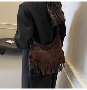 Detail van donkerbruine suède hobo tas met lange franjes en gepolijst metalen hardware