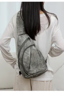 Détail du sac de poitrine gris en toile délavée avec trois poches à fermeture éclair