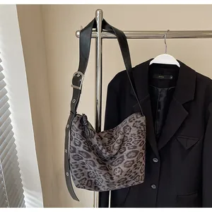 Détail du sac hobo léopard avec bandoulière réglable en cuir noir et boucle argentée