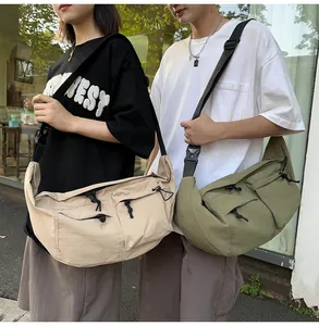 Detail of nylon messenger bag showing functional pockets and wide adjustable straps