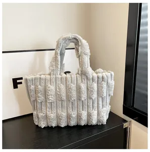 Detail of light gray plush tote bag showing soft vertical stripe fuzzy texture and handles
