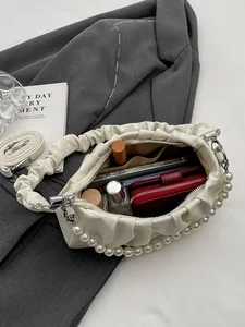 Chic beige pleated cloud bag with pearl strap and luxury shoulder strap on blazer