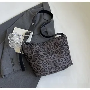 Détail du sac léopard gris avec bandoulière en cuir réglable et boucle métallique