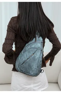 Détail du sac bandoulière vintage en cuir bleu avec trois poches zippées pratiques