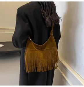 Bruine suède hobo tas met lange retro franjes getoond als een zijdelingse crossbody