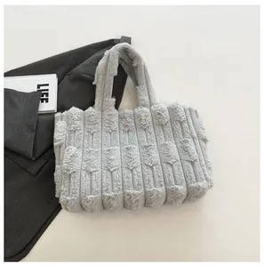 Detail of grey faux fur tote bag with vertical stripes and plush textures