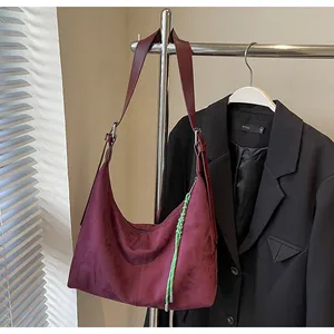Détail du grand sac cabas en daim bordeaux avec un accessoire de sangle tressée verte
