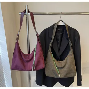 Détail de sacs hobo bordeaux et vert olive avec tirette tressée vert fluo contrastée