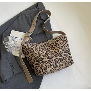 Sac à bandoulière léopard tendance avec sangle réglable sur un blazer gris chic