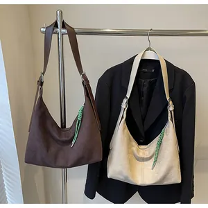 Détail de sacs hobo minimalistes en marron et gris avec tirettes de zip tissées vertes