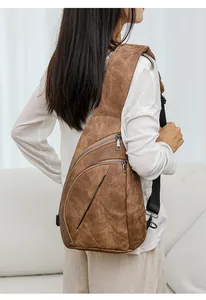 Vue détaillée d'un sac de poitrine en cuir marron vintage porté par un mannequin en intérieur