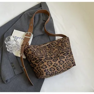 Détail du sac léopard avec bandoulière marron et boucle en métal argenté brillant
