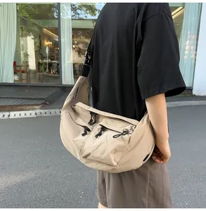 Macro view of khaki nylon crossbody bag with large capacity and double front zip pockets