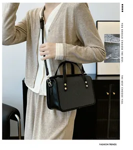Détail du sac à main carré avec panneaux en tissu écossais gris et ferrures dorées
