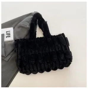 Detail shot of black plush tote bag featuring textured vertical stripes and soft faux fur